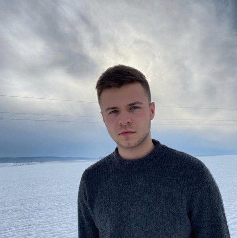 Man standing in a snowy landscape with a dramatic sky